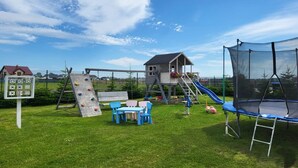 Un’area giochi con strutture per arrampicata, uno scivolo e un trampolino.