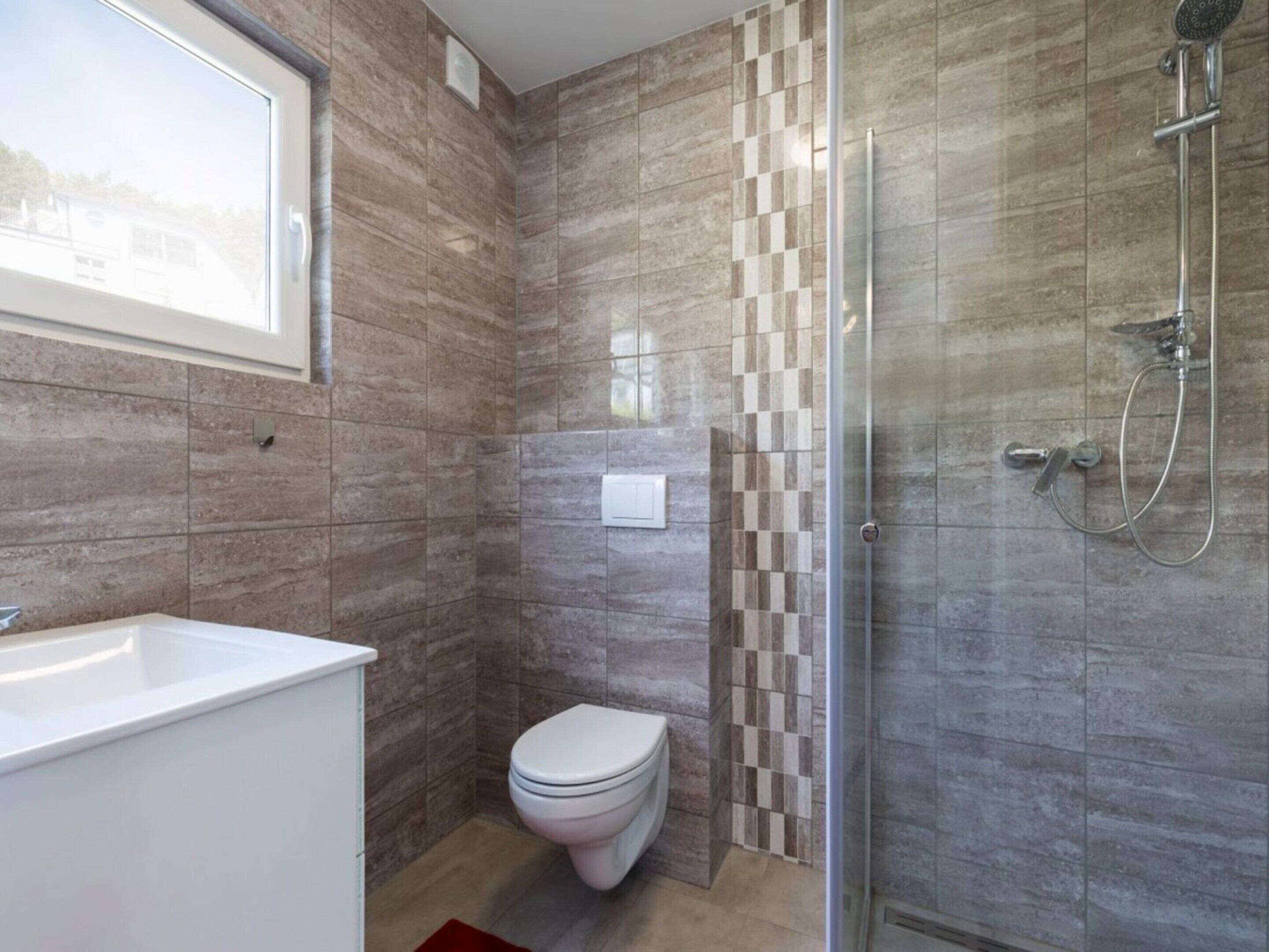 Ein modernes Badezimmer mit Dusche, Toilette und Waschbecken.