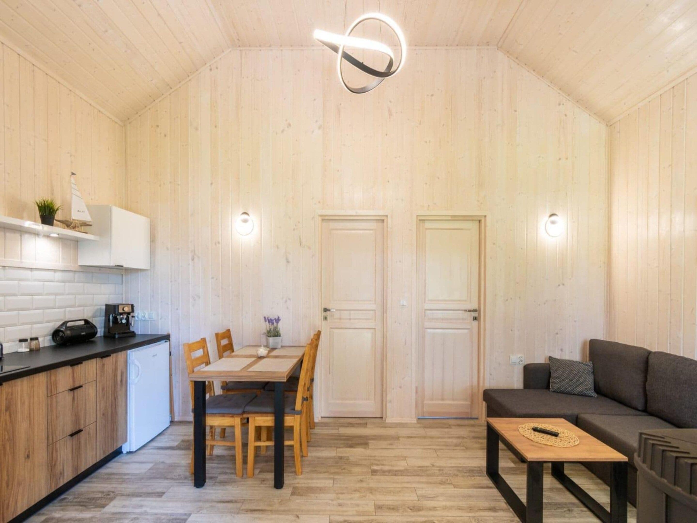 A compact living space with a dining area, kitchenette, and seating area.