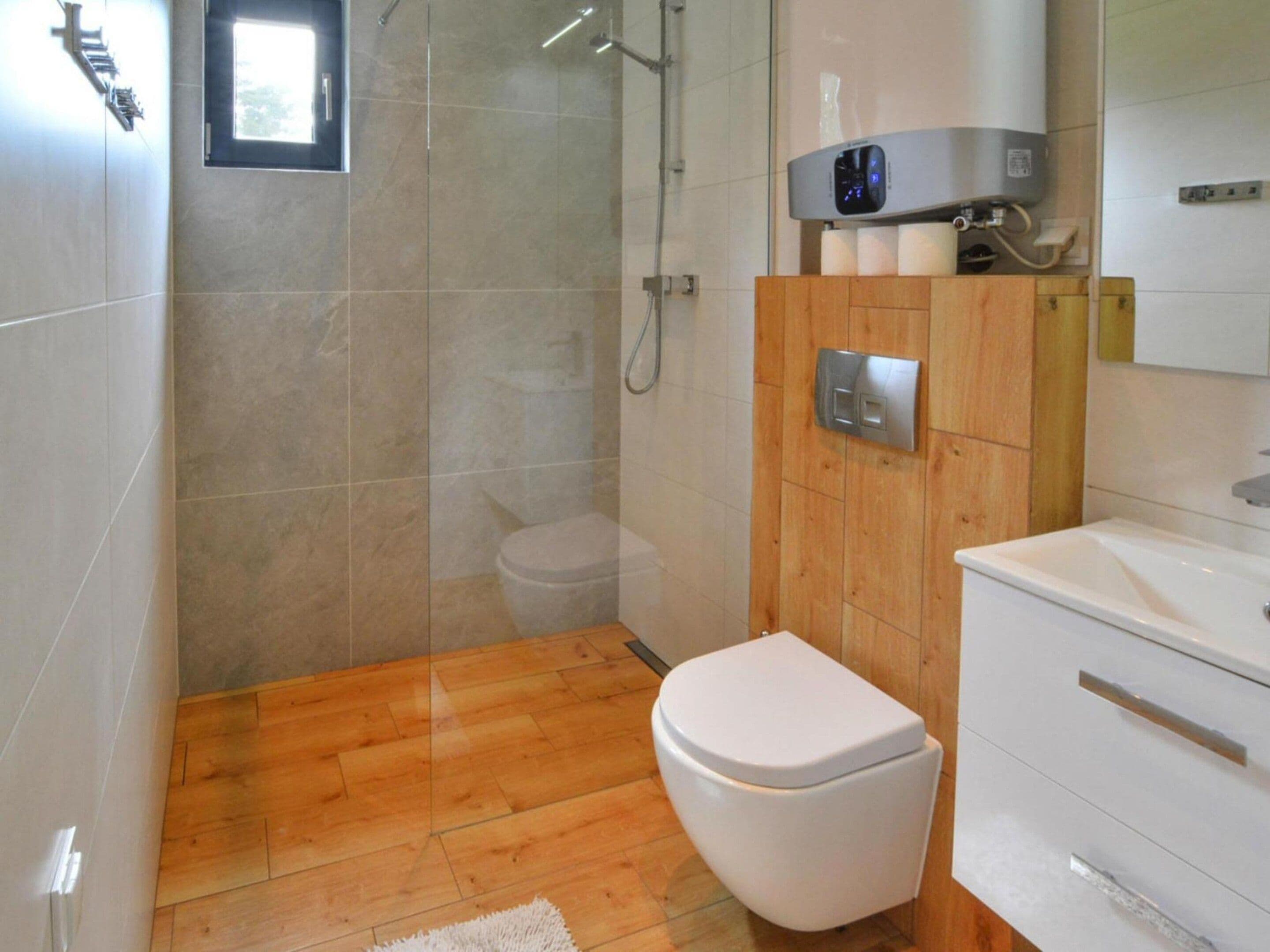A bathroom with a toilet, a shower, and a sink.