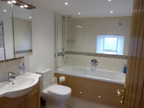 Un bagno moderno con lavandino, WC e doccia.