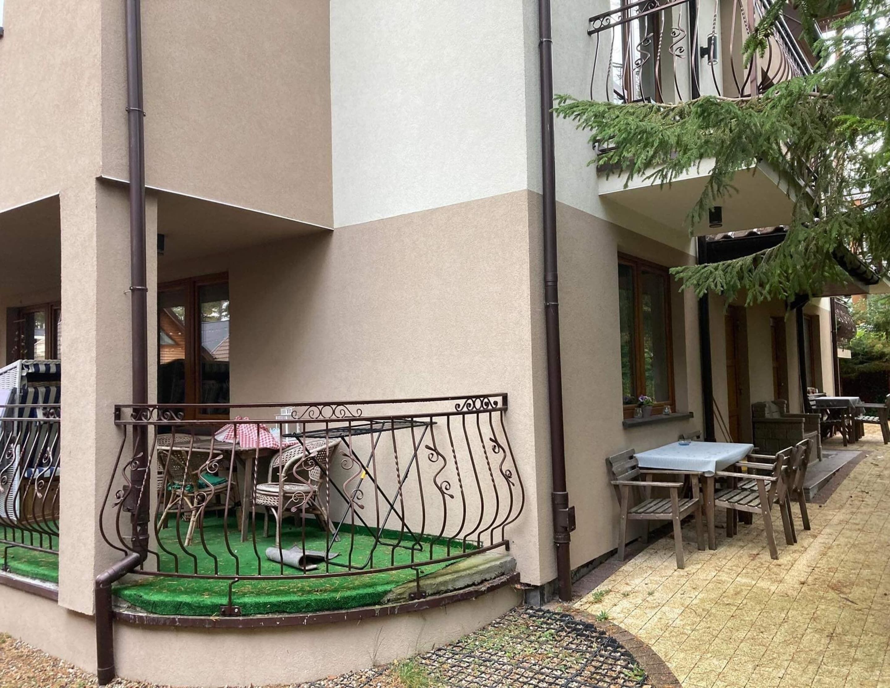 A courtyard with a covered seating area, a small table, and chairs.