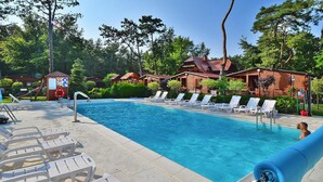 En swimmingpool med liggestole og et lille legeområde.