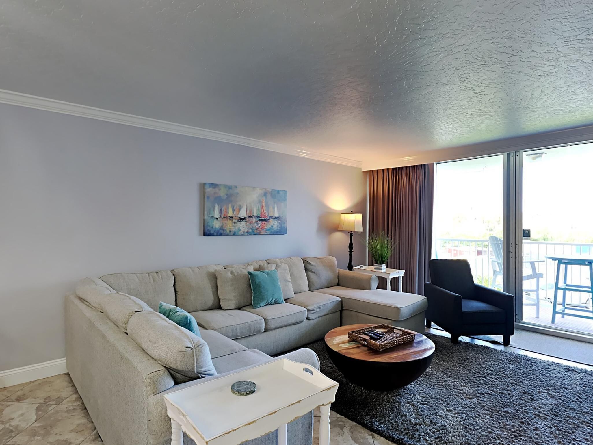 A living room with a beige sofa, a coffee table, and a painting on the wall.