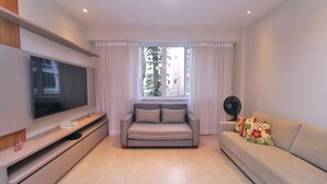 A modern living room with a flat-screen TV, a sofa, and a window with curtains. - D055 (Rio de Janeiro)