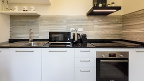 A modern kitchen with a Bosch oven, a coffee maker, and a microwave. - Silvy & Paul apartment by MMega (Florence)