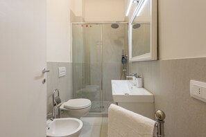 A modern bathroom with a glass-enclosed shower, a white sink, and a toilet. - Silvy & Paul apartment by MMega (Florence)