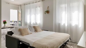 Un dormitorio moderno con una cama grande, un escritorio y una silla.