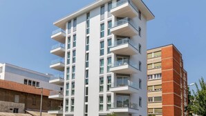 Un immeuble moderne à plusieurs étages, doté de balcons, de grandes fenêtres et d’un toit plat.