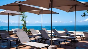 A deck with sun loungers and umbrellas overlooking the ocean. - 1 BR Golden Zone · Luxury Beach and Infinity Pool (Bucerías)