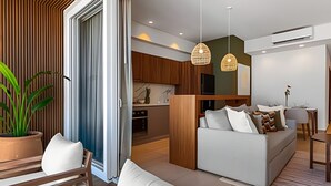 A modern living room with a sofa, a dining area, and a kitchen. - 1 BR Golden Zone · Luxury Beach and Infinity Pool (Bucerías)