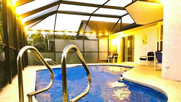Una piscina interna con scalette in metallo, una zona coperta e posti a sedere a bordo piscina.