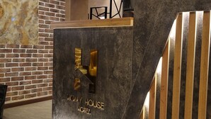 Una reception dal design moderno, con un logo e la scritta "HOMY HOUSE HOTEL" incisa.