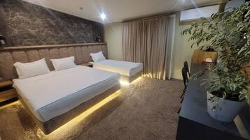 Habitación triple Deluxe, vistas a la ciudad | Colchones Select Comfort, decoración individual, mobiliario individual