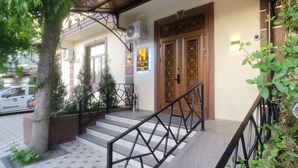 L'ingresso di un hotel con una scalinata, un cartello con la scritta "HOMY HOUSE HOTEL" e un'auto parcheggiata.