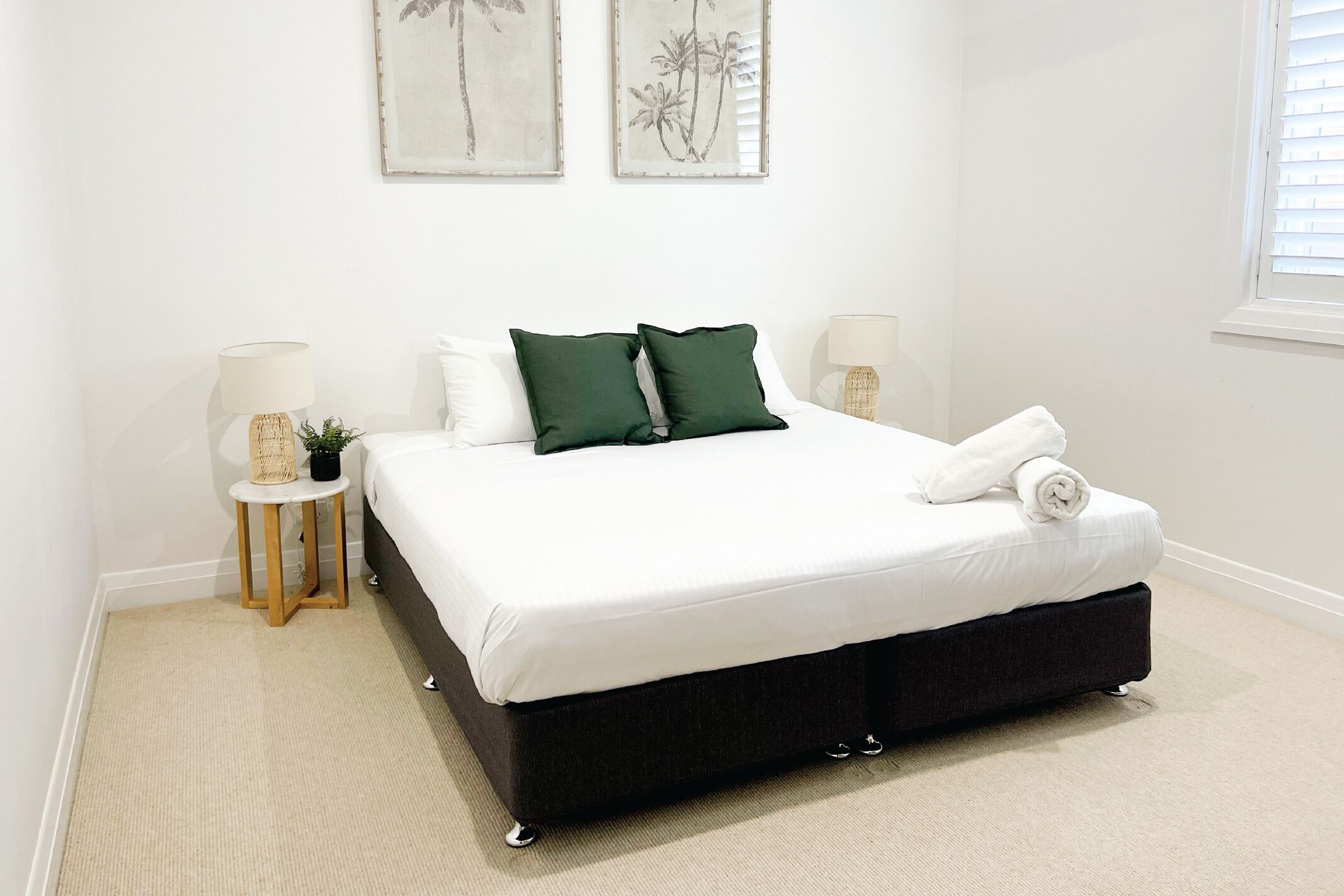 Un dormitorio con una cama grande, dos mesitas de noche y decoración en la pared.