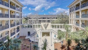 Un hôtel à plusieurs étages doté de balcons, d’un espace extérieur aménagé et d’une cour intérieure.