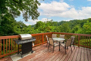 A wooden deck with a grill and outdoor furniture. - Smoky Mtn Escape | Indoor Pool, Arcade, Theater & Firepit Nights (Gatlinburg)