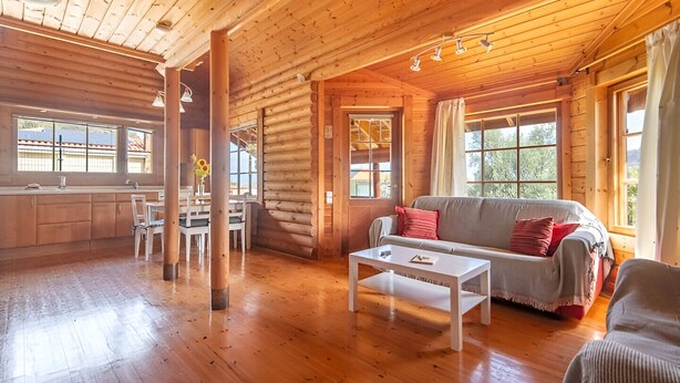 A log cabin interior with a dining area, a sofa, and a coffee table. - Serene 2-bedroom house with WiFi in Arucas (arucas)