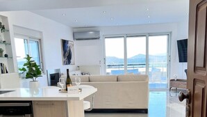 Una cocina moderna con lavavajillas, un comedor con sofá y un amplio ventanal con vistas.