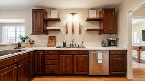A modern kitchen with wooden cabinets, a stainless steel sink, and a built-in dishwasher.