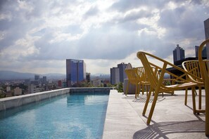 Relax by the rooftop pool with a stunning city view.