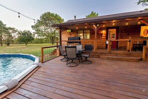 Une terrasse en bois avec une piscine, un espace salon extérieur et un coin barbecue.