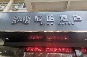 Exterior del Hotel Xihai con un letrero destacado y texto rojo iluminado.