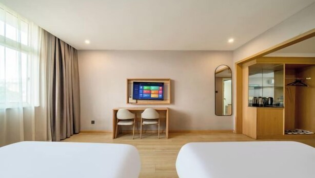 A hotel room with two beds, a desk with chairs, a TV, a mirror, and a wardrobe. - Qiha Hotel (Xiangshan North Gate Qingcao Alley) (Xiangshan)