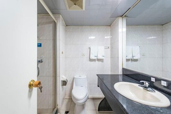 A bathroom with a toilet, sink, and mirror. - Qiha Hotel (Xiangshan North Gate Qingcao Alley) (Xiangshan)