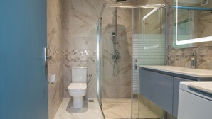 A modern bathroom with a glass-enclosed shower, a toilet, and a vanity with a mirror. - Little Gem by Corfu Escapes (Corfu)