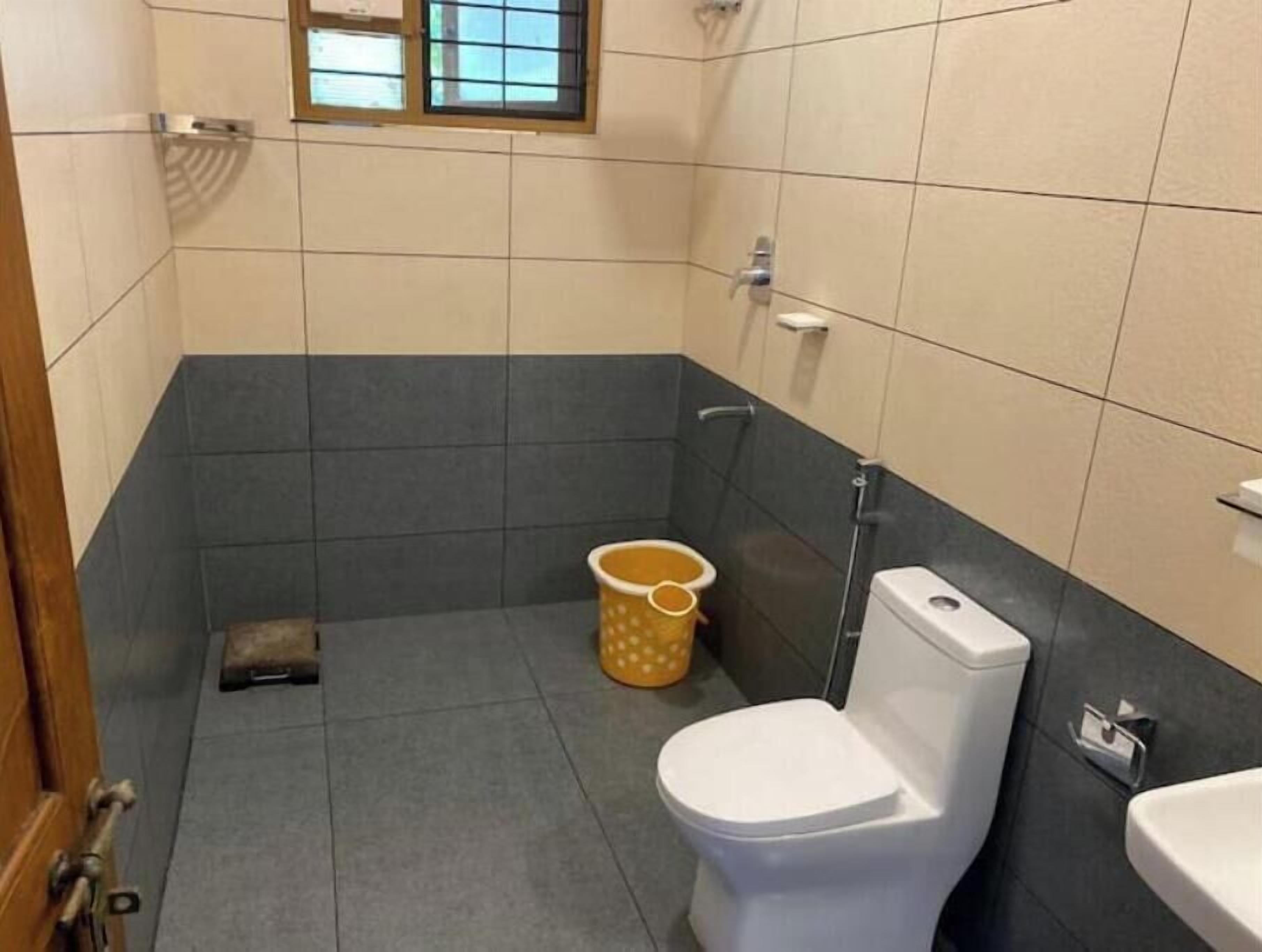 A small bathroom with a toilet, a bidet, and a window.