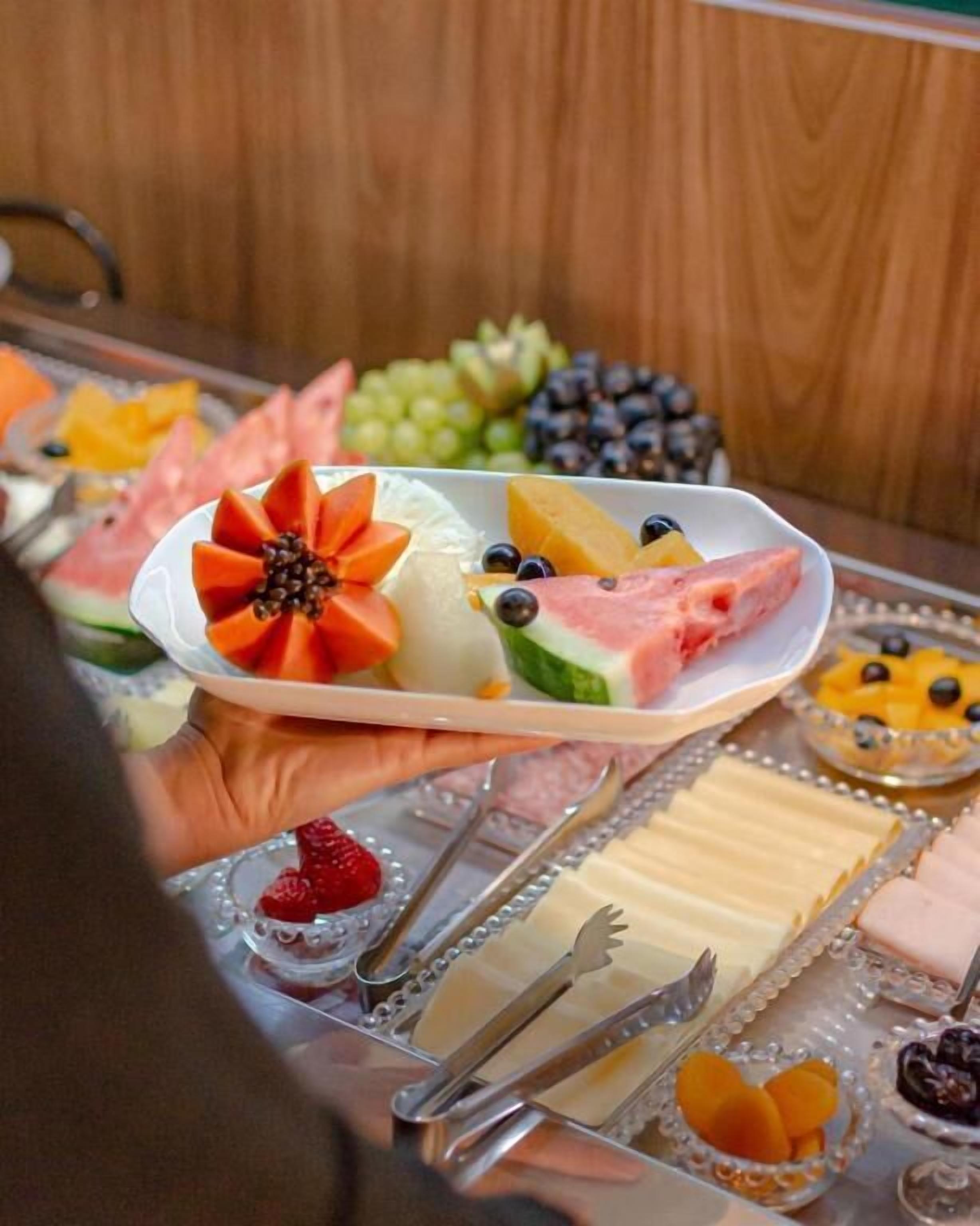 Un plat amb fruita variada i formatges, sobre un fons de fusta.