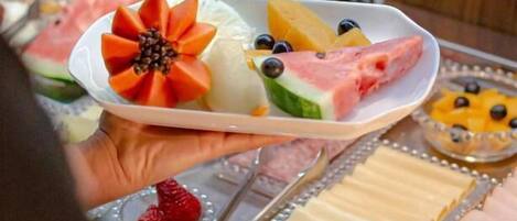 Un plato con frutas y quesos variados, sobre un fondo de madera.