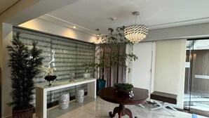A spacious living area with a modern design, featuring a large round table, a decorative plant, and a contemporary light fixture. - Hotel Imperatriz Premium (Telemaco Borba)