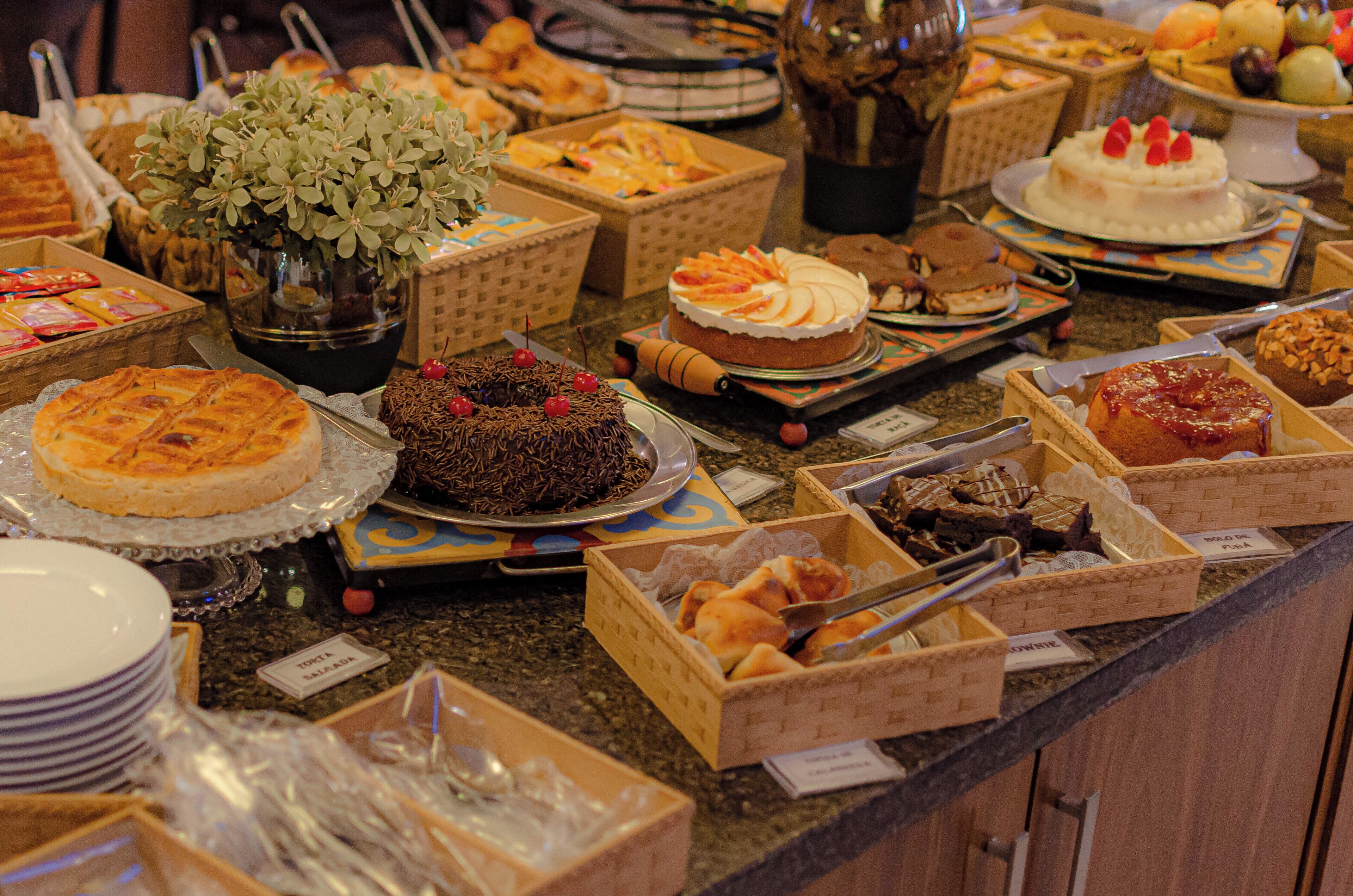A buffet with various desserts and a potted plant.