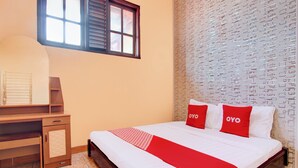 A hotel room with a bed, a desk, and a window. - Hotel O Griya Mustika Syariah (Ngemplak)