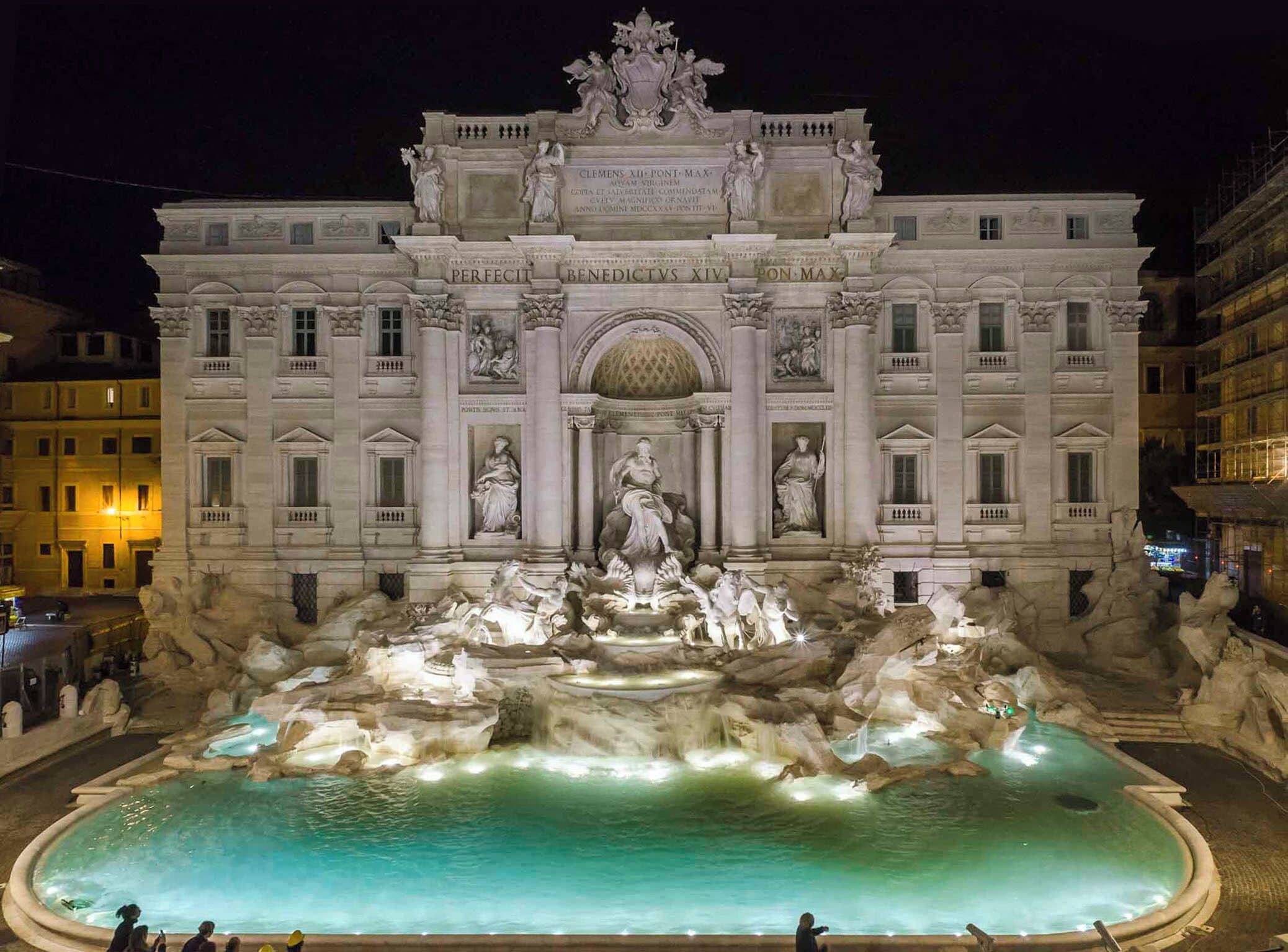 Un imposant bâtiment, orné d’une grande fontaine à l’avant, avec des statues et des inscriptions.