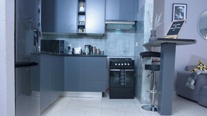 Cocina compacta con horno integrado, microondas y cafetera.