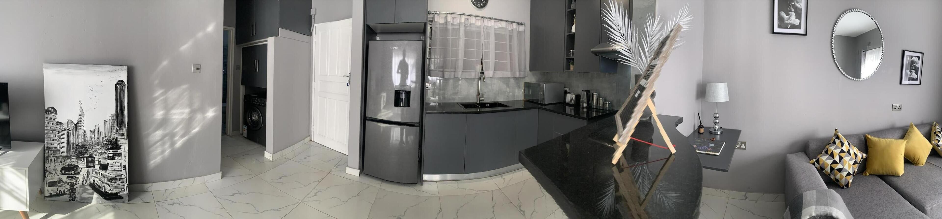 A modern kitchen with a built-in refrigerator, a sink, and a coffee machine.