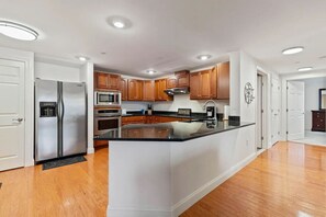 Een koelkast, een vaatwasser, kookgerei, borden en bestek