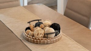 Una mesa de comedor con un centro de ovillos de lana y cuentas de madera.