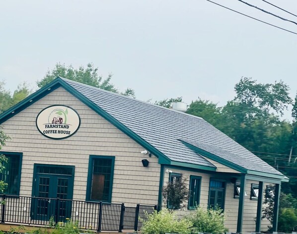 A farmhouse-style building with a sign that reads "Farmstand Coffee House."