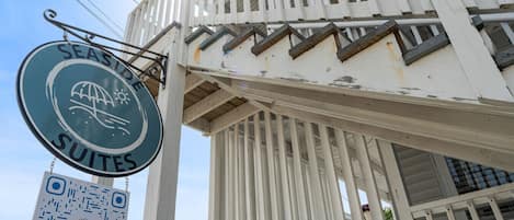 A building with a sign for 'Seaside Suites' and a QR code.
