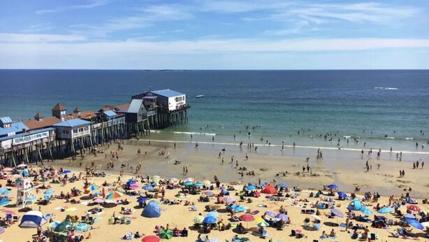 A beach with a pier and beach umbrellas. - Cozy 1 BR Suite Steps to the Beach (469) (Old Orchard Beach)