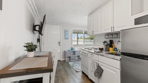 A kitchen with white cabinets, a stainless steel refrigerator, and a wooden countertop. - Stylish 1BR Suite Steps to the Beach 467 (Old Orchard Beach)