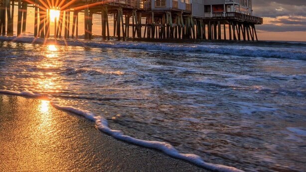 A beachfront property with a pier extending into the ocean, featuring multiple levels with balconies. - Stylish 1BR Suite Steps to the Beach 467 (Old Orchard Beach)