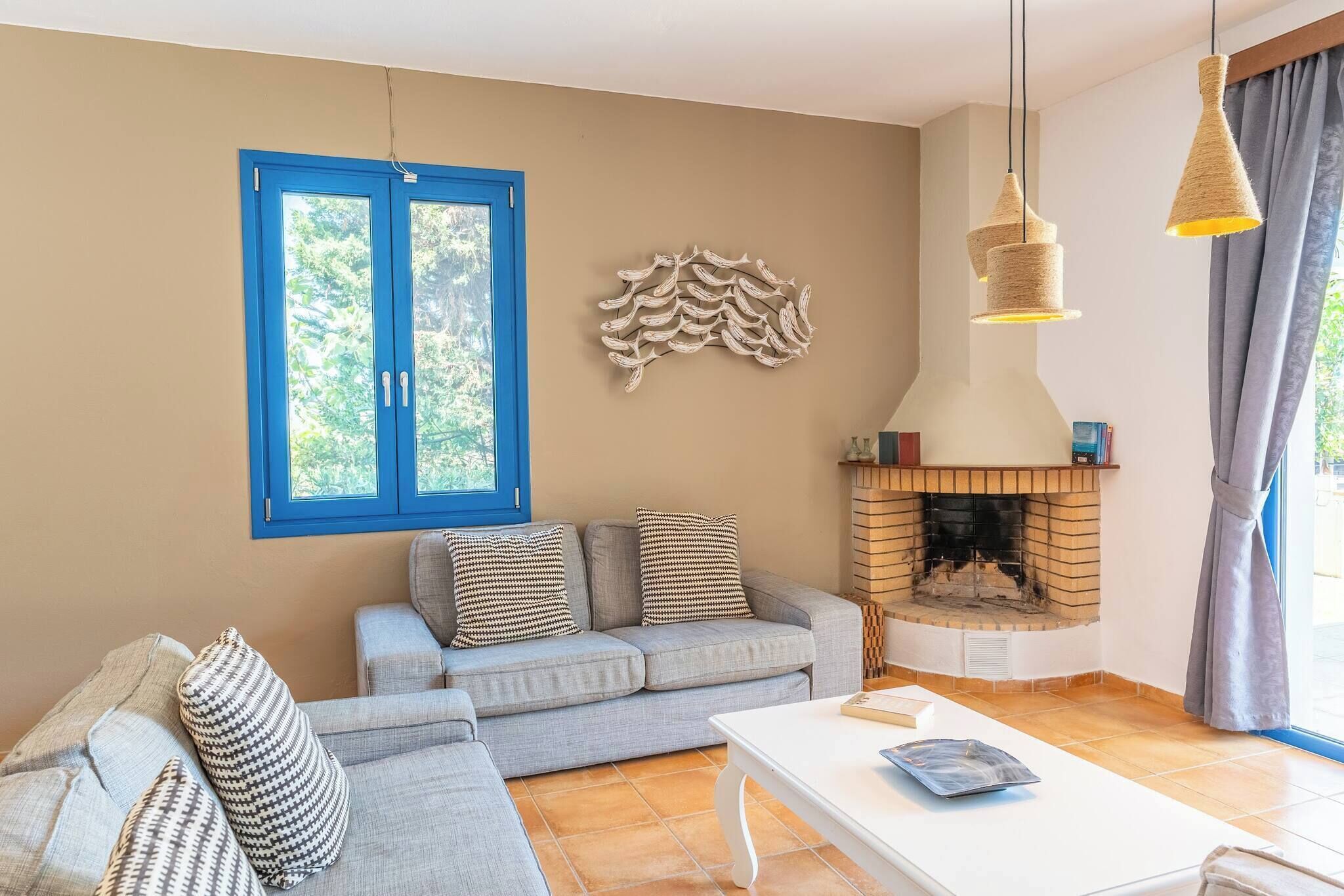 Ein Wohnzimmer mit einer Couch, einem Kamin und einem Fenster mit blauen Rollläden.
