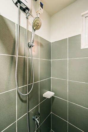 Een douche, handdoeken, zeep, toiletpapier