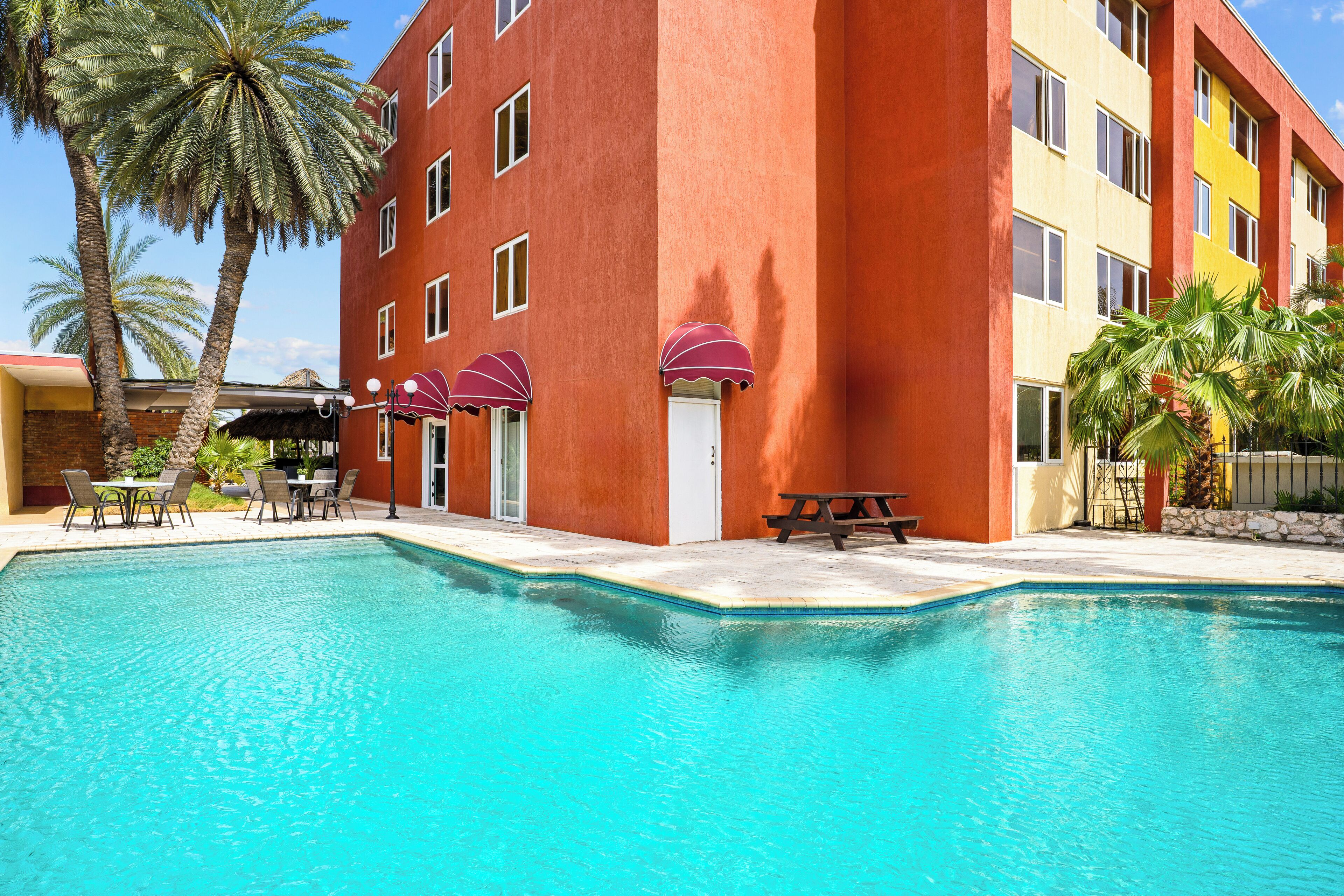 Una piscina al aire libre, sombrillas, sillones reclinables de piscina